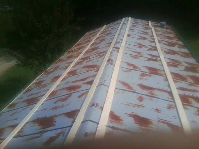 Rusted metal roof panels with new wood purlins before replacement — Storm Damage Roof Repair in Canon by Roofing Brothers