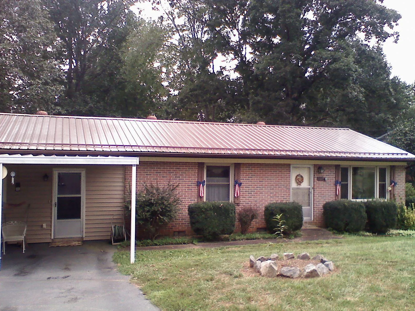 Bronze metal roof and carport on a brick ranch home — Roof Repair work by our crew in Canon