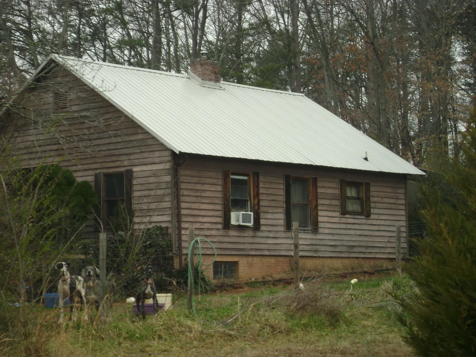 White metal roof on an old wood sided farmhouse, from a Metal Roof Installation job in Canon